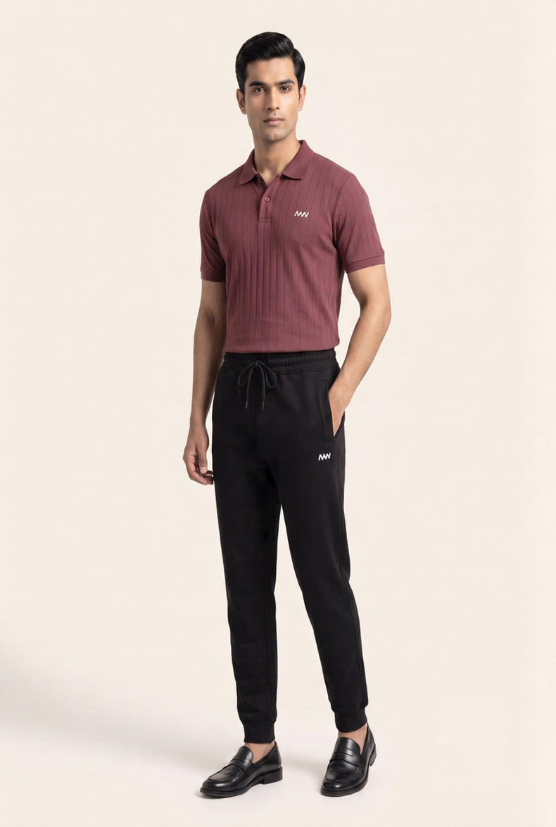Man wearing burgundy ribbed polo shirt and black joggers with logo, styled for modern men's fashion