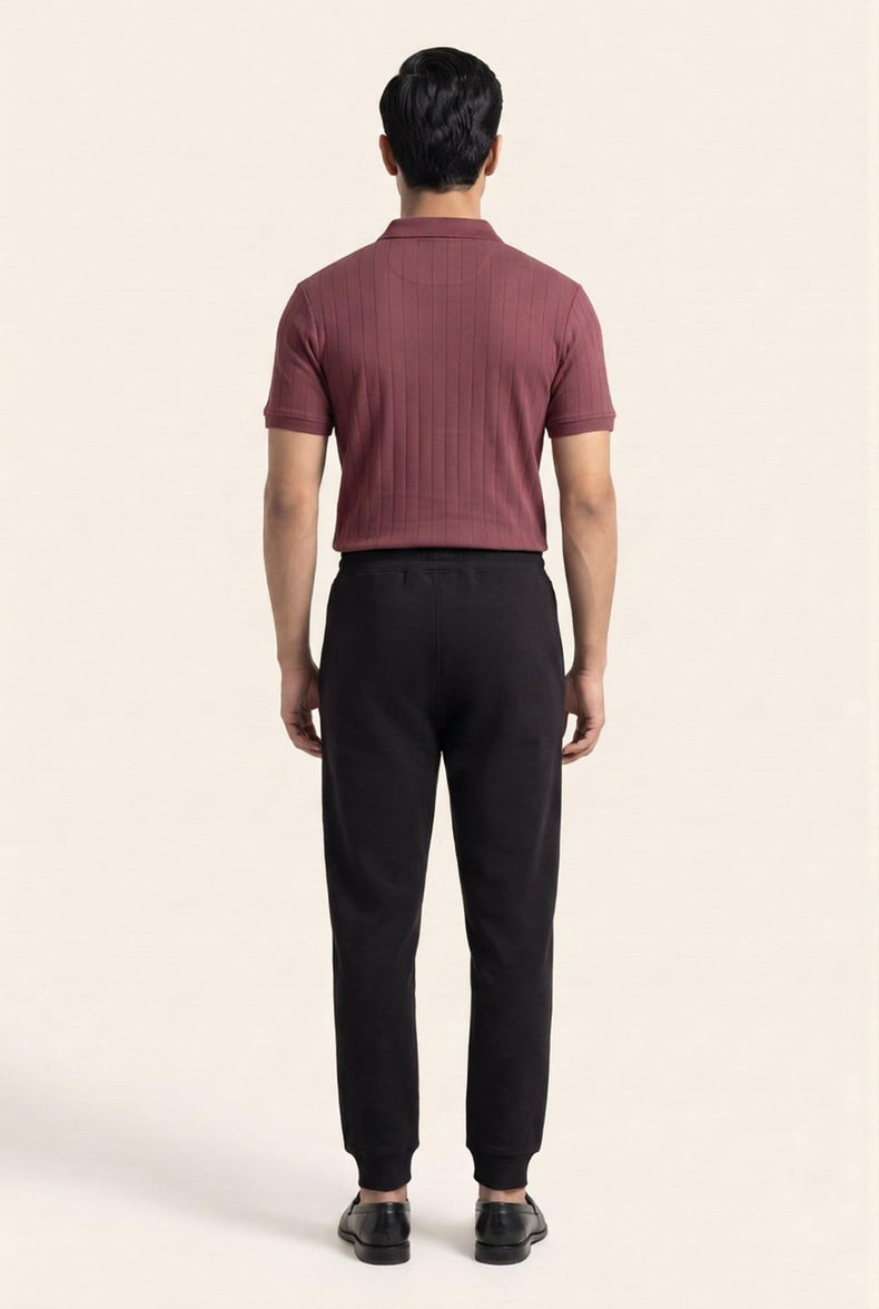 Man wearing burgundy ribbed polo shirt and black joggers, back view — modern men's casual wear