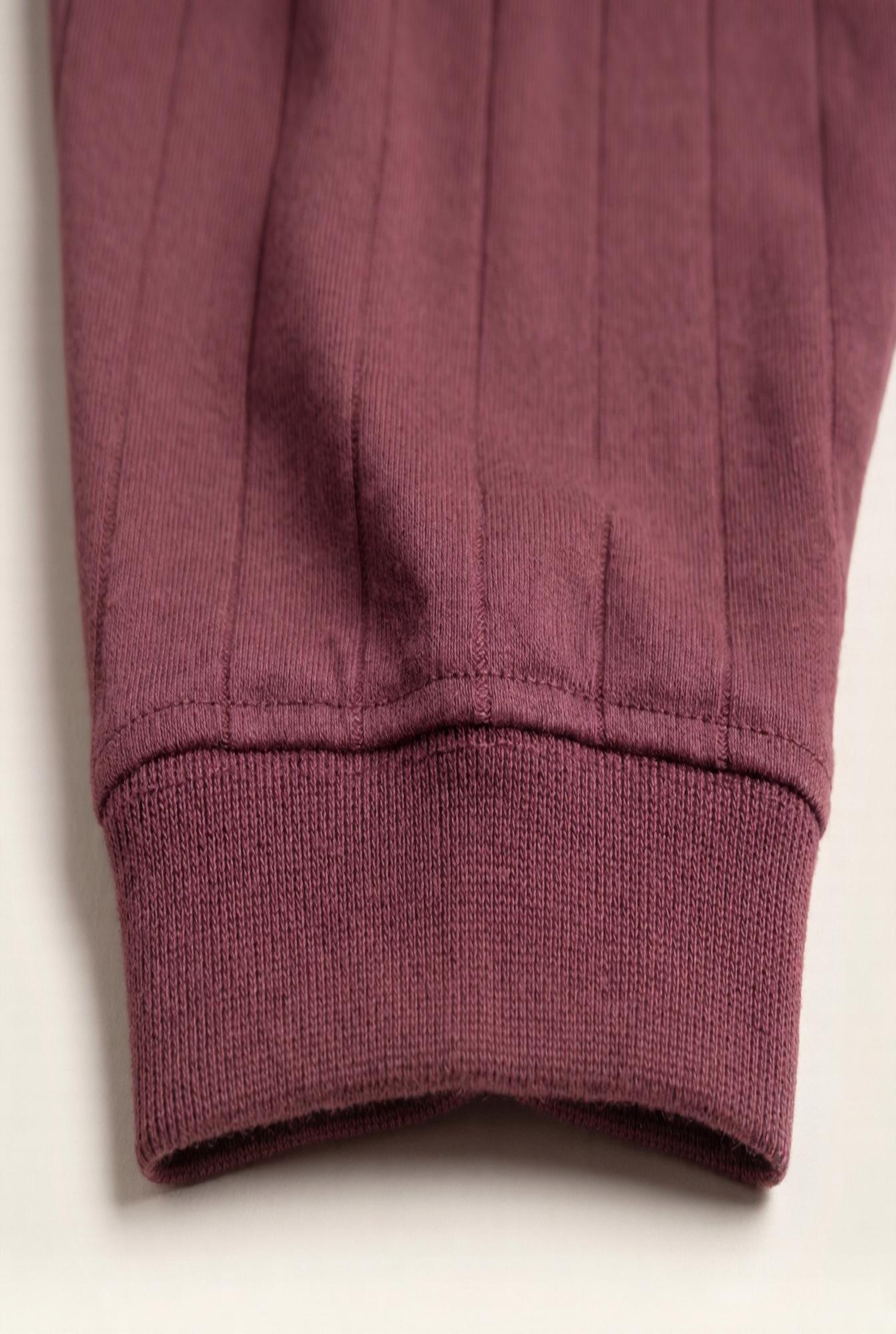 Close-up of burgundy men's jogger cuff with ribbed knit and clean stitching for premium comfort.
