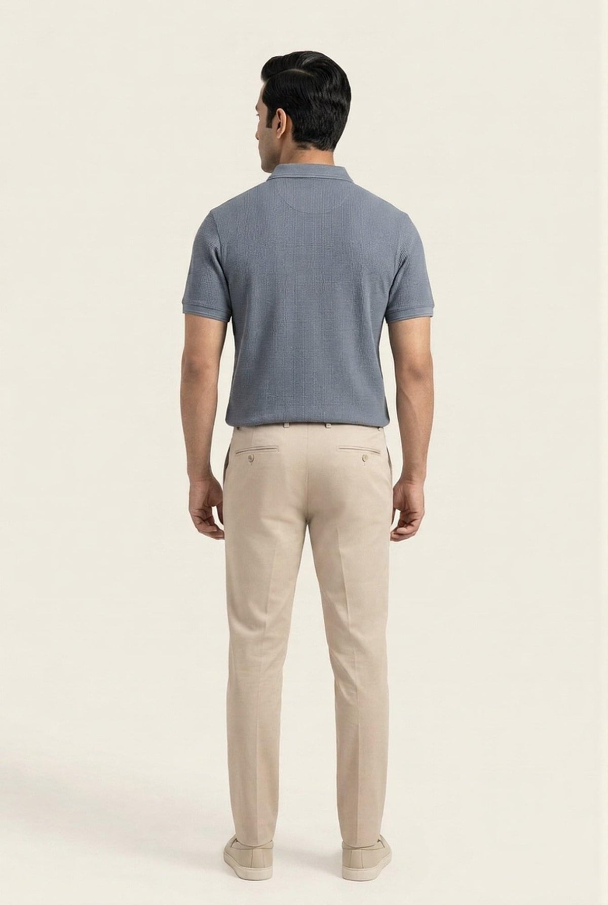 Man wearing gray textured polo shirt and beige chinos, back view — modern men's casual outfit