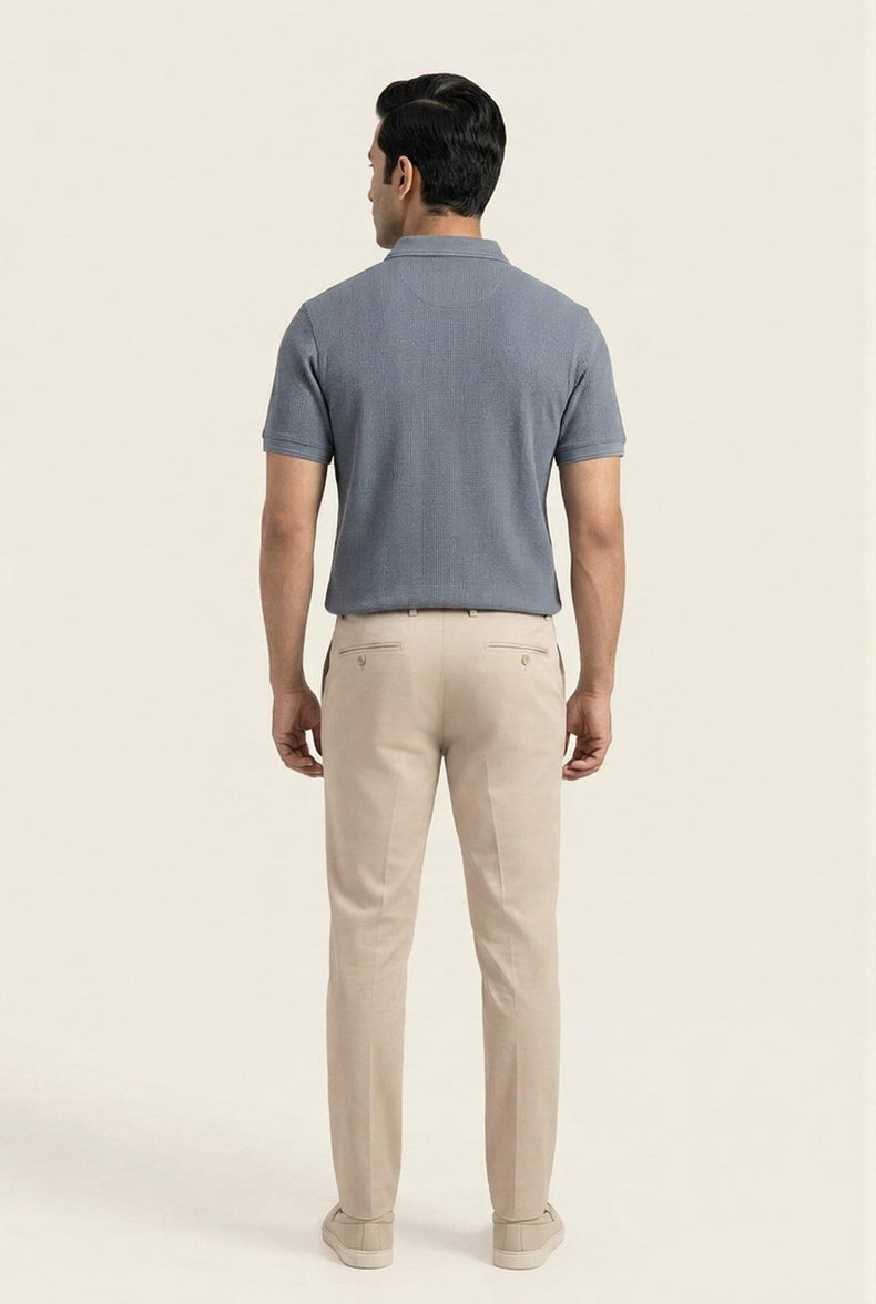 Man wearing gray textured polo shirt and beige chinos, back view — modern men's casual outfit