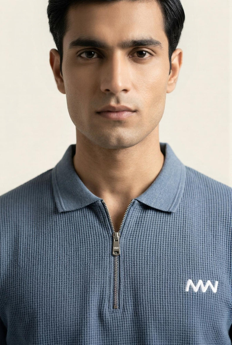 Man wearing blue textured half-zip polo shirt with MW logo, modern men's fashion
