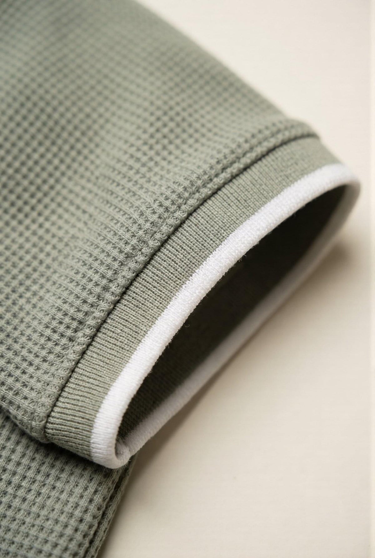 Olive green waffle knit men's shirt sleeve with white trim, premium fabric detail