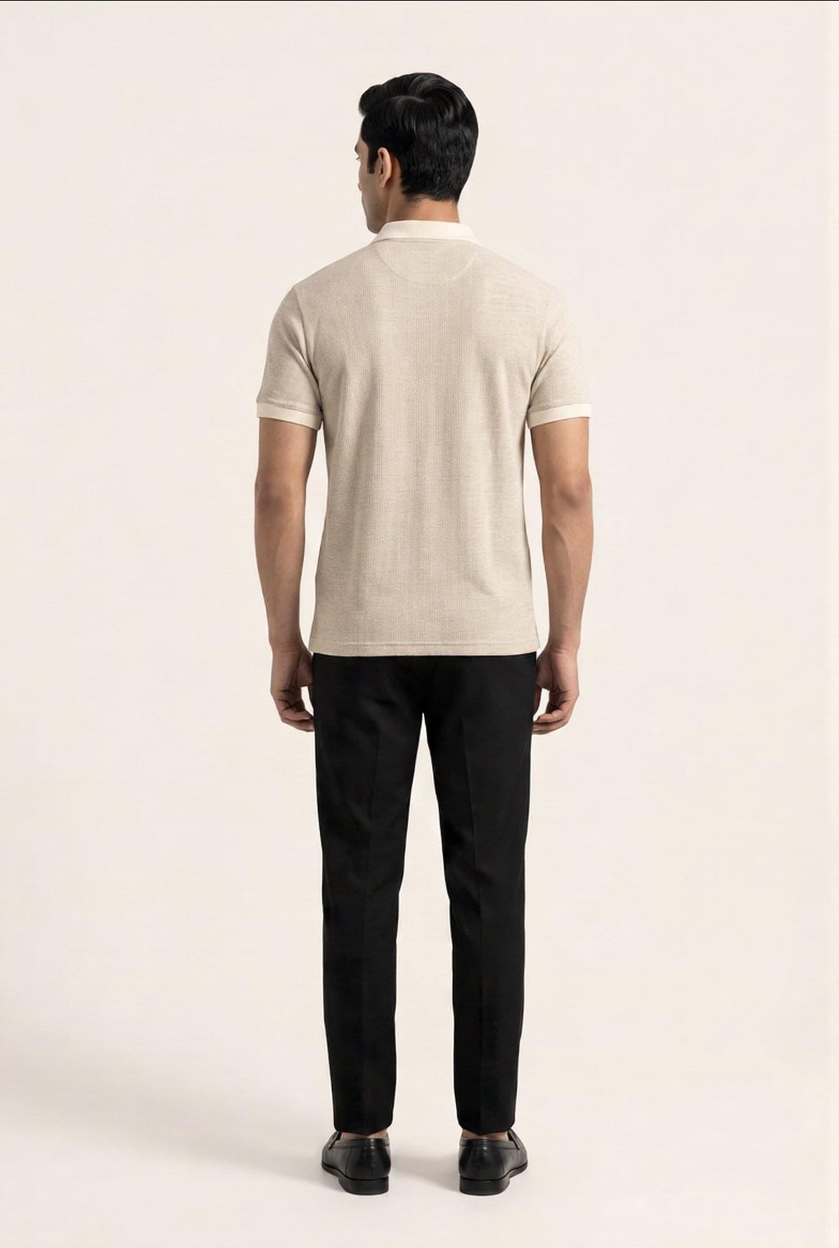 Man wearing beige polo shirt and black trousers, back view — premium men's clothing style
