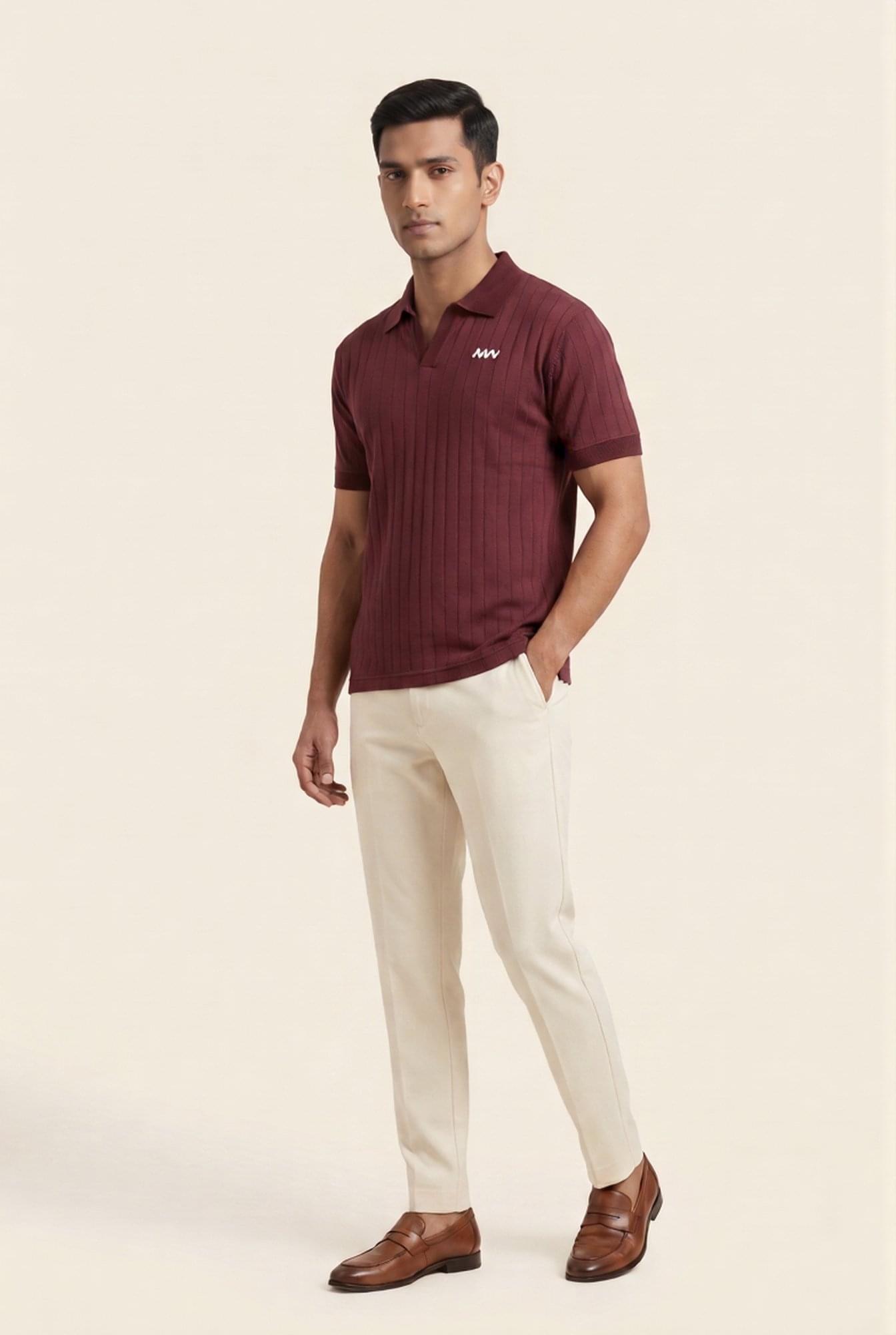 Man wearing burgundy ribbed polo shirt with white logo, cream trousers, and brown loafers — modern men's fashion