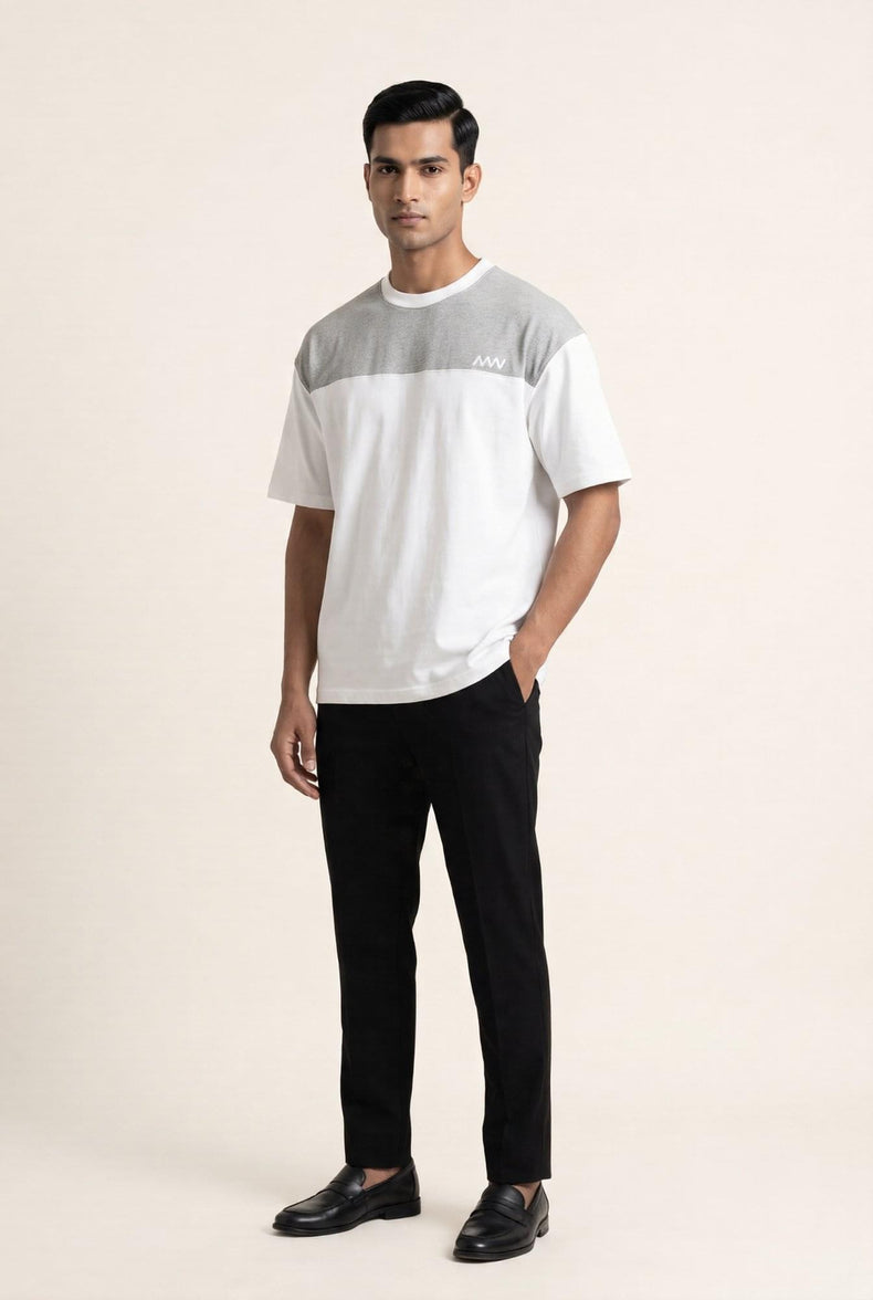 Men's white and gray color-block t-shirt with black trousers and loafers — modern casual style