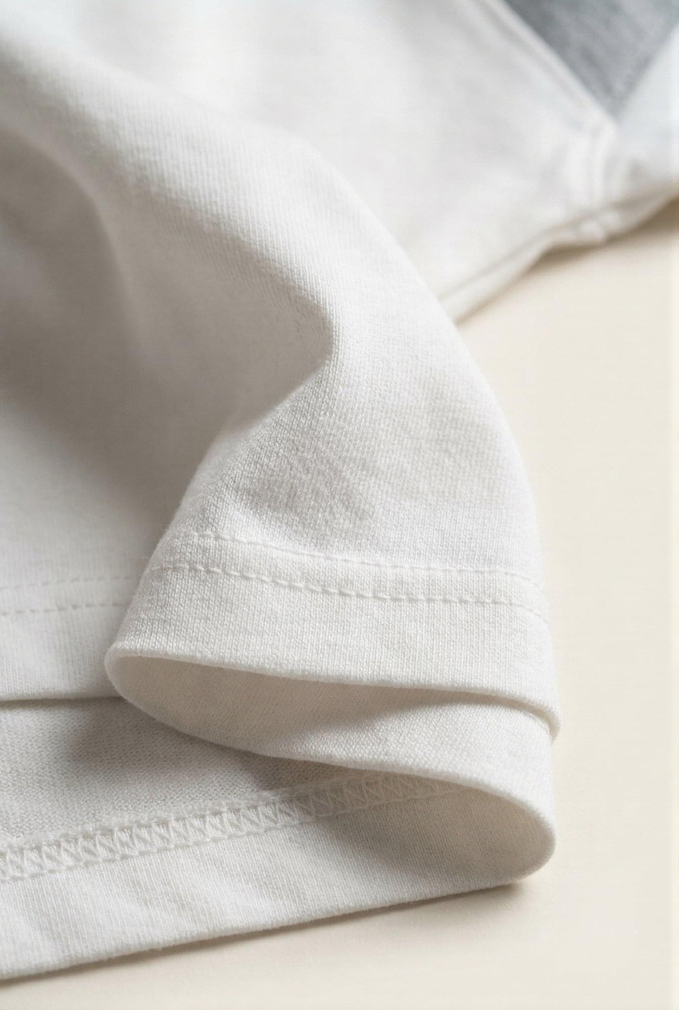 Close-up of premium white men's t-shirt sleeve with clean stitching and soft fabric texture