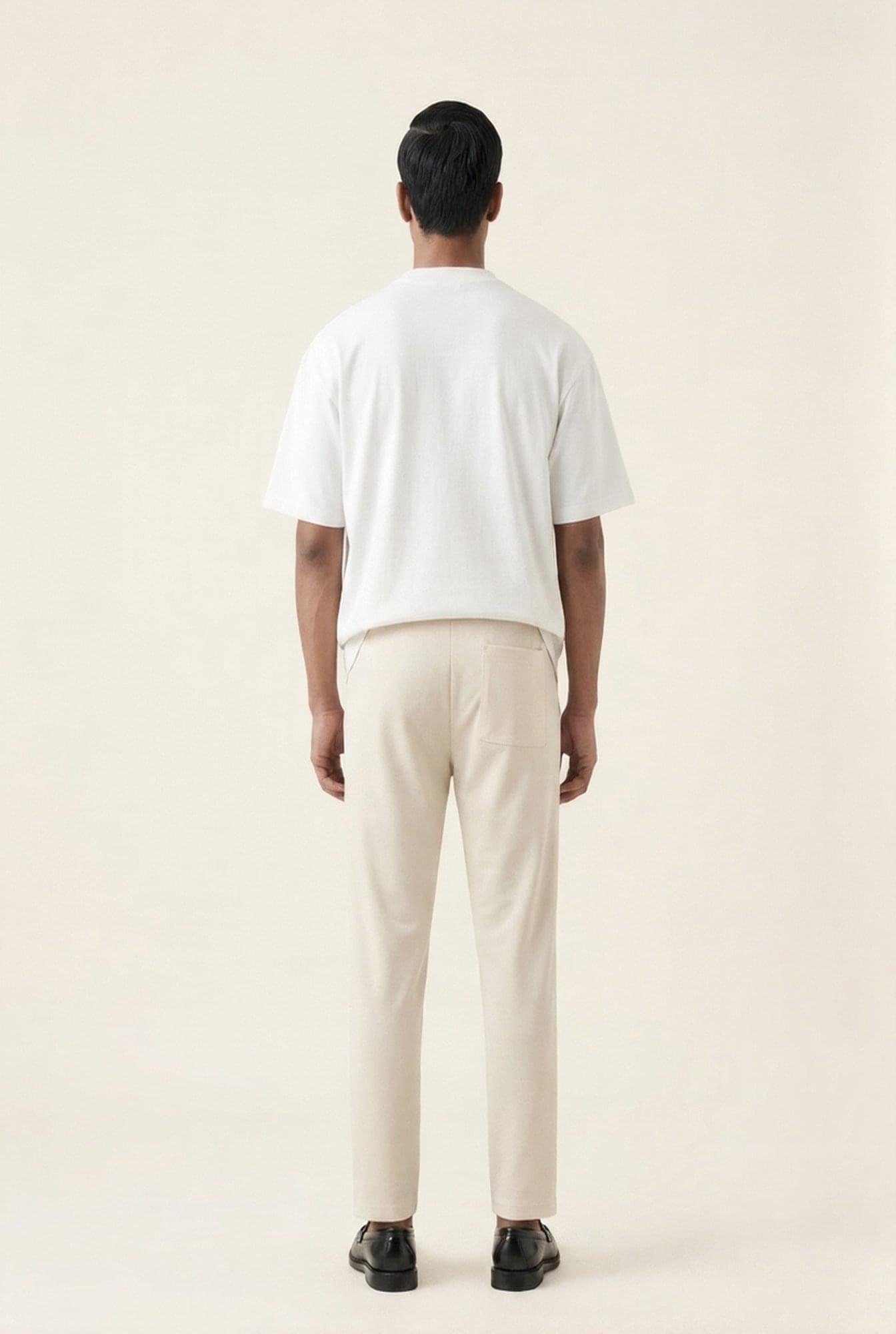 Man wearing white t-shirt and beige chinos, back view — modern men's casual outfit