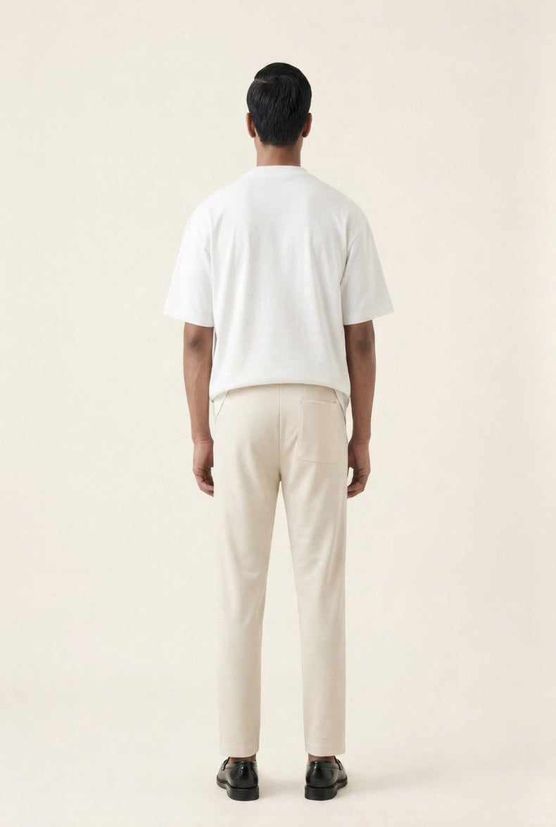 Man wearing white t-shirt and beige chinos, back view — modern men's casual outfit